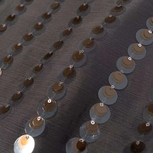 Vue macro détaillée du tissu gris foncé avec des rangées de paillettes verticales