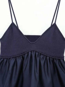 Detail of navy blue V-neck top showing ribbed knit texture and satin fabric contrast