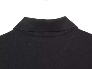 Macro detail of ribbed knit collar on black sleeveless dress with clean seam stitching