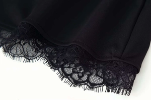 Detailed macro view of delicate black eyelash lace trim on a summer dress hemline