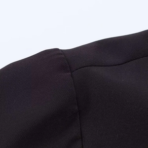 Detail close-up of shoulder seam stitching on black minimalist polo top for women