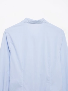 Detailed back view showing waist darts and smooth texture of light blue poplin shirt
