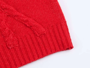 Gros plan sur un pull en tricot torsadé rouge avec texture et finition de l'ourlet