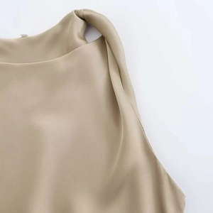 Detalle de blusa de satén oro champán que muestra el cuello redondo y la textura suave