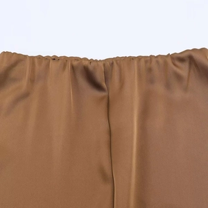 Detail of elastic waist on brown satin midi skirt showing smooth silk-like texture