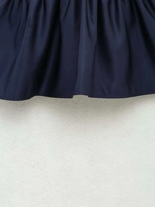 Detailed view of navy blue pleated fabric texture on a knit V-neck sleeveless top
