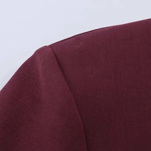 Gros plan des coutures et de la texture du tissu d'une robe ballon cintrée bordeaux