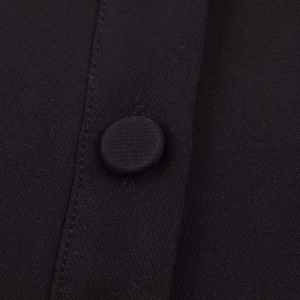 Detail shot of the fabric covered button and stitching on this black polo collar shirt