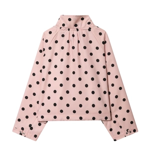 Detail view of pink polka dot jacket showing lapel collar and adjustable button cuffs