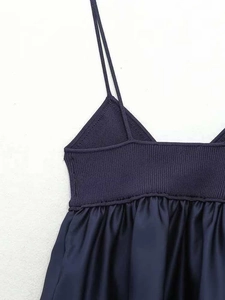 Detail of navy blue V-neck knit camisole with thin straps and pleated fabric textures