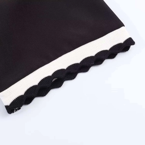 Close-up of black POLO top featuring wavy edge cuffs and striped ribbed texture detail