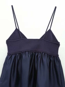 Detail of navy blue V-neck top showing ribbed knit bodice and pleated fabric joining