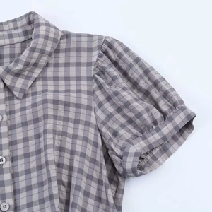 Detail of puff sleeves and plaid fabric texture on a stylish short dress for women