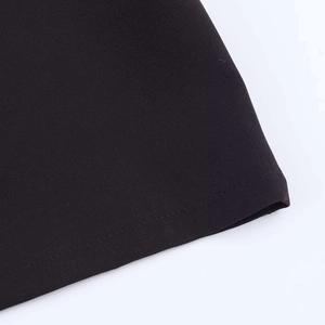 Close-up of the high-quality black woven fabric texture and neat stitching on the bottom hem