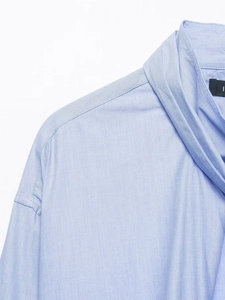 Close-up of light blue shirt showing fine cotton fabric texture and collar stitching