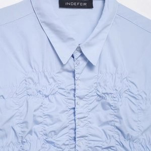 Light blue poplin shirt featuring elastic ruching details and tonal button closure