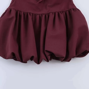 Vue macro détaillée de la robe bordeaux avec un ourlet bulle élégant en tissu plissé