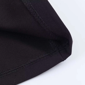 Detail shot of high-quality overlock stitching on black minimalist polo top hem