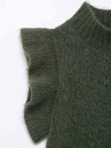 Close-up of dark green wool knit vest featuring soft ruffles and mohair texture