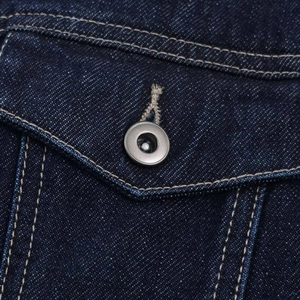 Gros plan détaillé d'une poche de veste en jean bleu foncé avec coutures contrastées