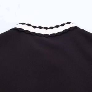 Detail of knitted polo collar with scalloped edges and black and white stripes