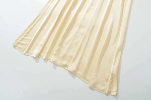 Detail of a light yellow satin maxi dress showing the smooth fabric texture and hemline
