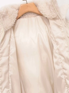 Detailed close-up of soft faux shearling collar and smooth satin lining on beige jacket