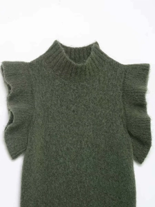Detailed texture of dark green knit sweater with ruffled sleeves and soft wool finish