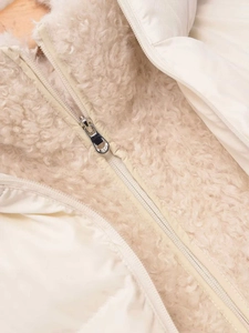 Detail of cream fleece fabric and smooth polyester panels with silver metal zipper