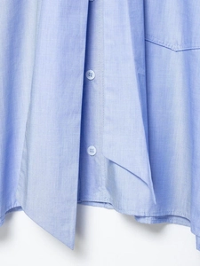 Detail of light blue button-up shirt featuring fine texture fabric and elegant bow tie tie