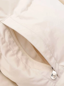 Detail of side pocket and silver D-ring zipper pull on cream hooded fleece jacket