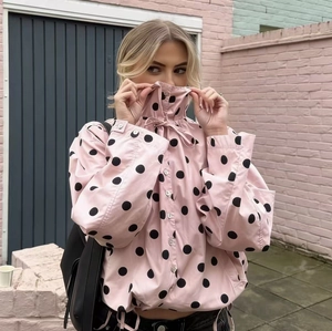 Women's light pink long-sleeved jacket with black polka dots and drawstring collar