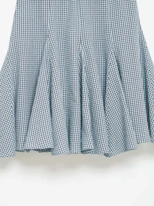 Detail of blue and brown checkered seersucker fabric with gored skirt hem and stitching