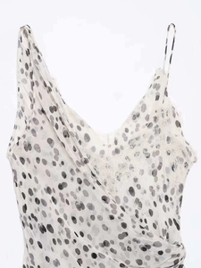 Vue détaillée du col en V avec dentelle florale fine et motifs à pois gris artistiques