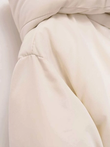 Macro shot of off-white puffer jacket showing shoulder seams and premium fabric texture