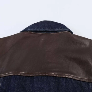 Vue détaillée du dos de la veste avec patchwork en cuir marron et denim bleu foncé