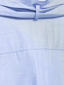 Detail shot of light blue fabric texture and belt loop stitching on the waistline