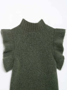 Detail of dark green knit vest featuring fuzzy wool texture and ruffled sleeve layers