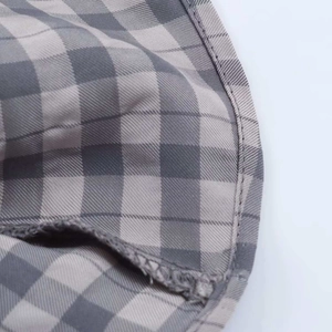 Macro shot of grey gingham fabric texture and fine stitching detail on summer dress