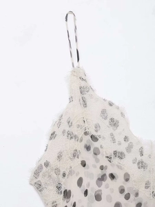 Détail de dentelle cils blanche délicate et tissu à pois sur une fine bretelle de caraco