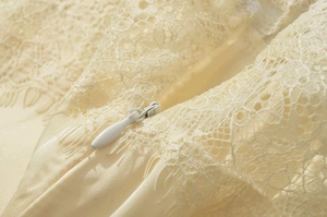Detail view of high-quality invisible zipper on a cream lace and satin dress