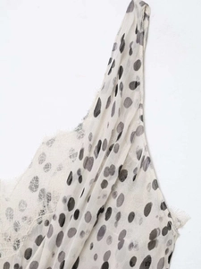 Détail de la bordure en dentelle cil et du motif à pois sur le décolleté du caraco
