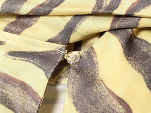 Detailed macro view of zebra print fabric featuring a transparent button and fine stitching