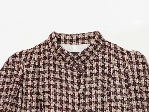 Detailed close-up of tweed jacket stand collar and burgundy houndstooth woven fabric texture