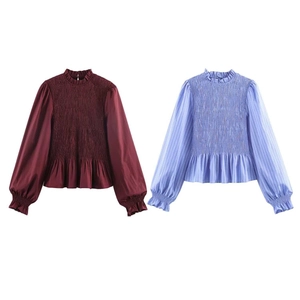 Detail of smocking texture and ruffle collar on a long sleeve striped cotton shirt