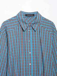 Vue détaillée du tissu à carreaux et des boutons-pression en métal argenté sur une chemise