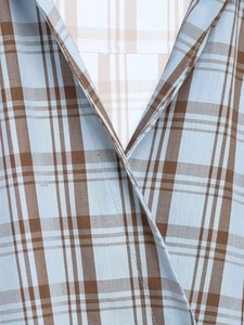Close-up detail of blue and brown plaid pattern fabric and neckline stitching on a shirt