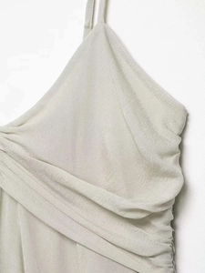 Detailed view of beige V-neck ruched bodice and delicate straps on a summer top
