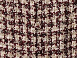 Close-up of tweed jacket fabric with red checkered pattern and golden silk threads