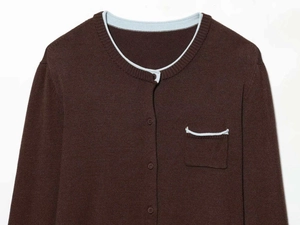 Detail of dark brown knit cardigan with light blue piping and buttons on white background
